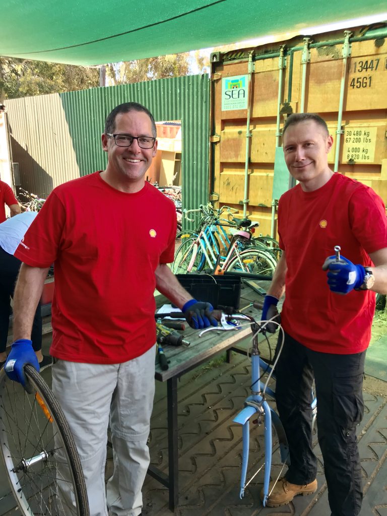 Two Shell volunteers fixing a bike at Bicycles for Humanity.